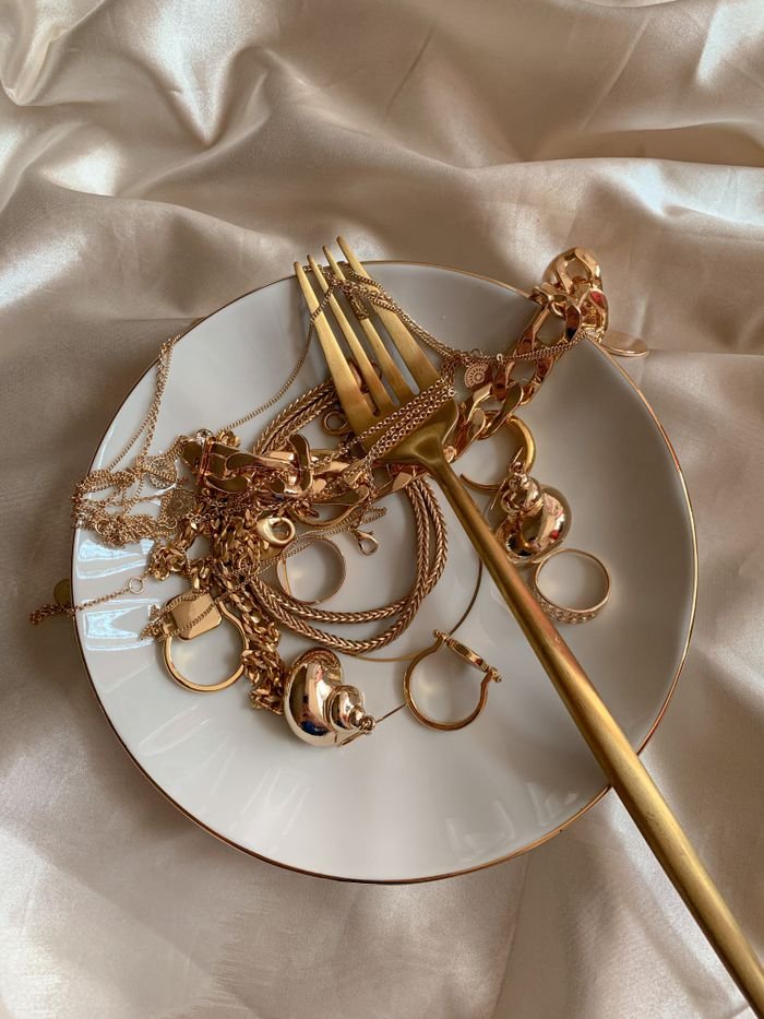 A collection of luxurious gold jewelry elegantly displayed on silk fabric for a sophisticated look.